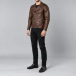 Angled full-length view of a man in a men's brown leather biker jacket with black jeans and black boots