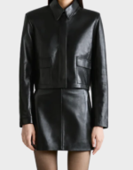 Women's boxy black lambskin cropped jacket on a model, front view, closed to the neck with two flap pockets at the waist