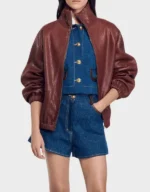 Women's oversized brick red pebbled leather jacket worn open on a model, showing the stand collar and elasticated cuffs